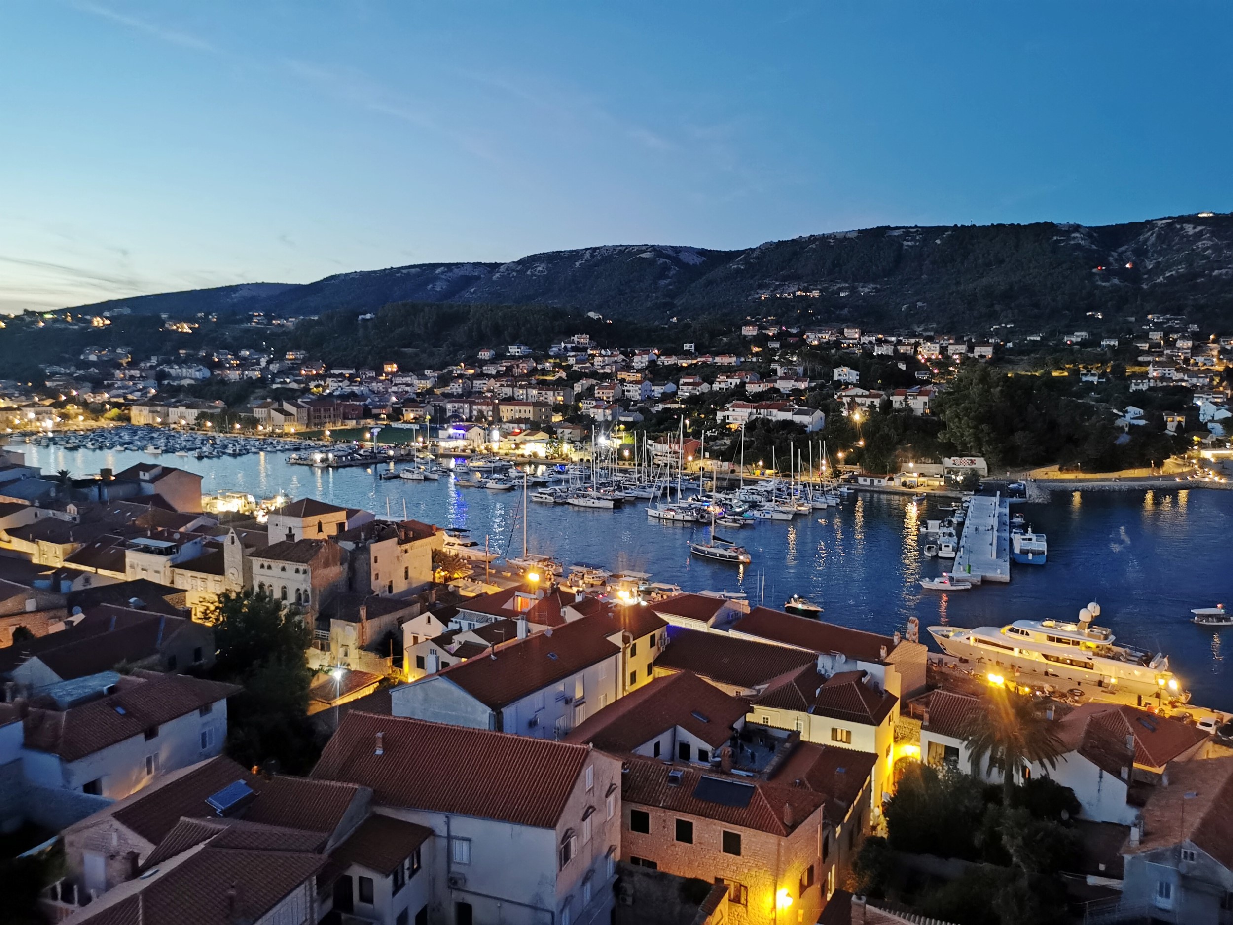 high-angle-view-townscape-by-sea-against-sky